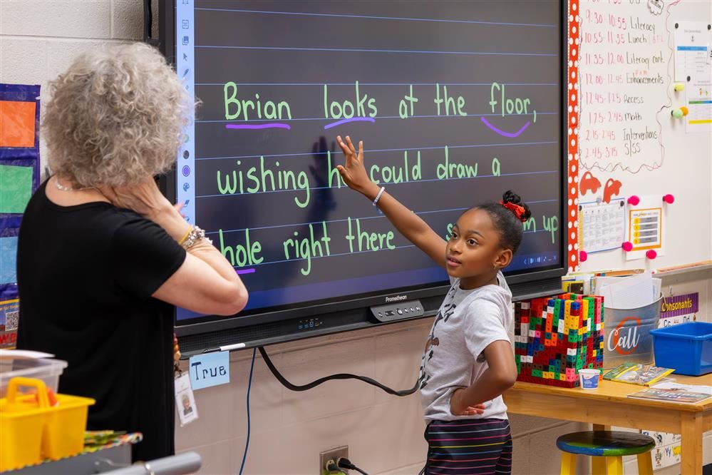 Teacher with student at active board