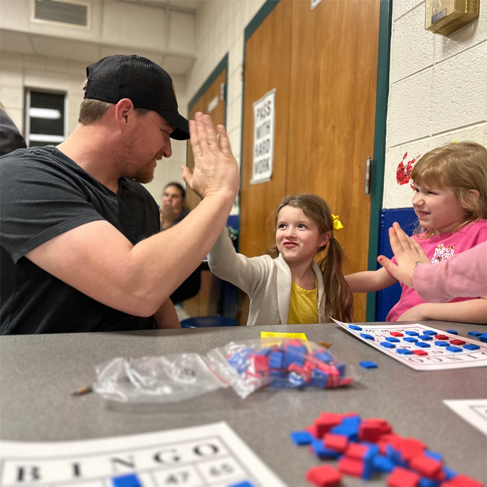  A dad high fives his daughter during a bingo game
